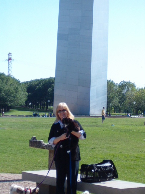 Sherra holds Oreo in front of the arch.